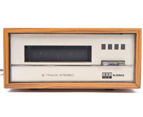 A vintage BSR McDonald AC mains&nbsp;8-track stereo cartridge player with teak wood effect&nbsp;covering / case. Measures 21c