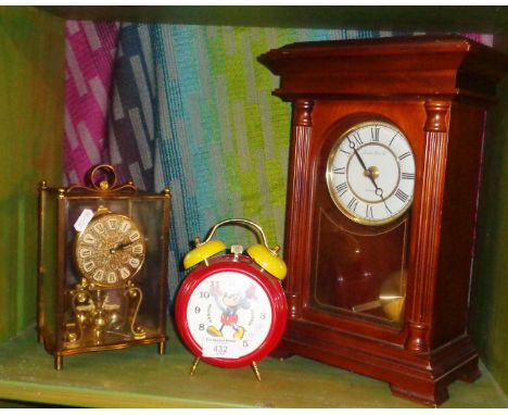A Mickey Mouse alarm clock, an Anniversary clock and a mantle clock
