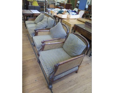 An Edwardian double caned mahogany bergere suite, with scroll carved arms and cabriole legs with ball and claw feet, comprisi