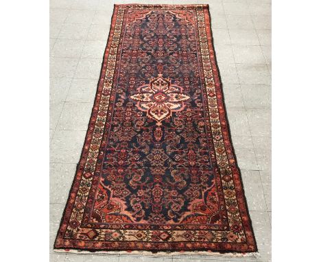 An Eastern hand made terracotta ground rug/runner, 284 x 115cms