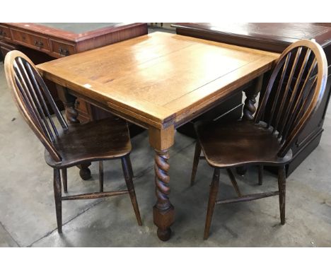 A pair of Ercol Golden Dawn elm and beech Windsor chairs and an early 20th Century oak barleytwist draw leaf table 