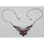 1 Collier WG 14ct. mit kleinen Brillanten bis zu ca. 0,03ct., wohl geschliffene Rubine bis zu ca. 6
