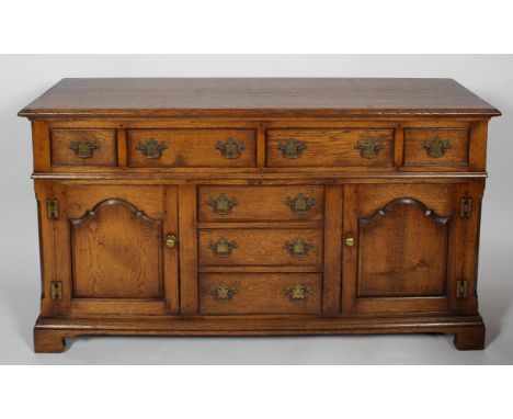 A Georgian 'Welsh' style oak dresser base, a 'T' arrangement of doors, flanked by a pair of arch panel doors, 89cm high x 61c