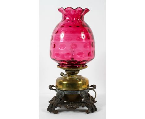A Victorian converted oil lamp, with cast metal pierced rocaille base, with brass reservoir, converted for electricity and cr