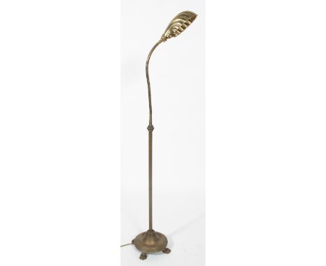 An early 20th century brass adjustable floor lamp, with shell  shaped shade and adjustable stem, on reeded column and base, o
