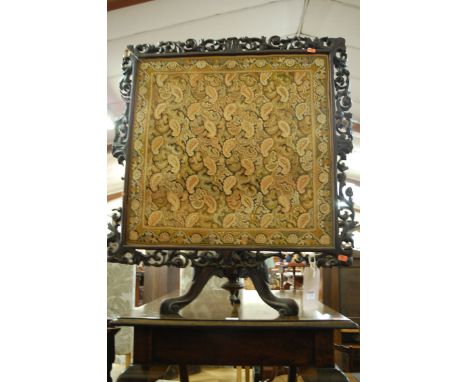 A Victorian and later adapted carved mahogany fire screen, having floral embroidered inset panel 