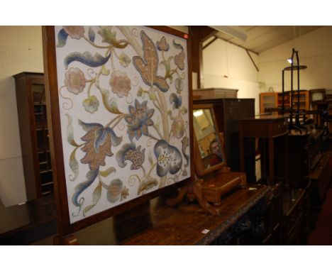 An early 20th century mahogany framed and floral embroidery inset fire screen; together with a Victorian mahogany swing toile