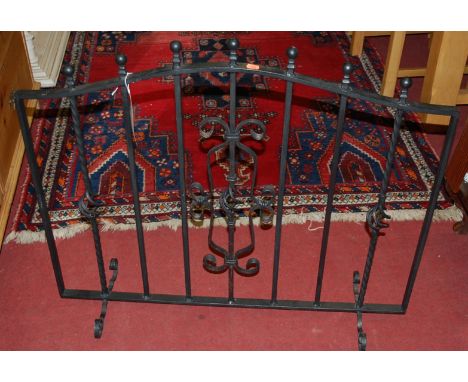 A black painted wrought iron fire screen