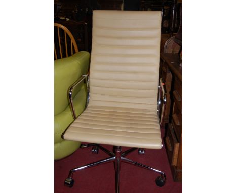 After Charles Eames - A chromed metal and cream leather upholstered EA118 revolving desk chair, having gas-tilt lift mechanis