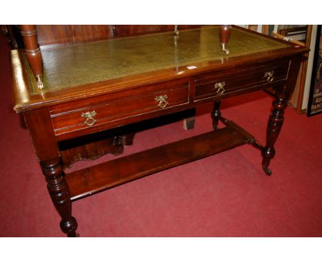 An Edwardian walnut and gilt tooled green leather inset two-drawer writing table, raised on ring turned tapering supports, wi