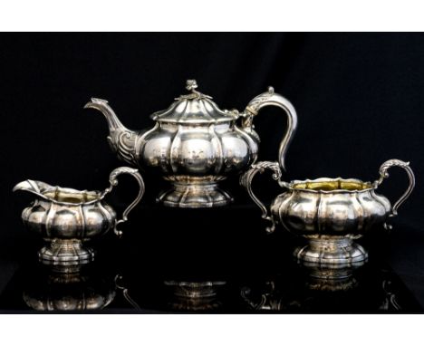 A George IV three piece silver melon form tea service, comprising teapot, two handled sugar bowl and cream jug, each with lob