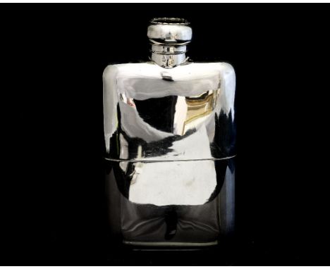 An Edwardian silver hip flask, of cushion form, with detachable gilt lined drinking cup, the screw cover with bayonet fitting