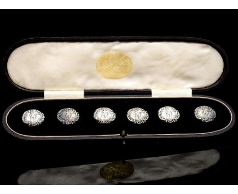 A cased set of six late Victorian silver buttons, each with embossed decoration of a figure in classical dress playing a lute