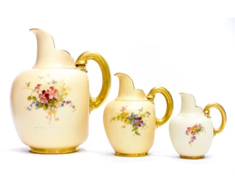 A graduated series of three Royal Worcester blush ivory jugs, the largest with date cypher for 1906, florally decorated, gilt