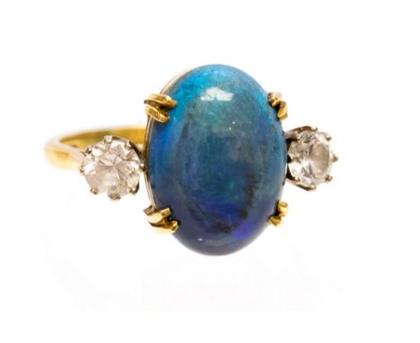 A black opal and white sapphire 18ct yellow gold three stone ring, the central claw set opal cabochon measuring approx 15 x 1