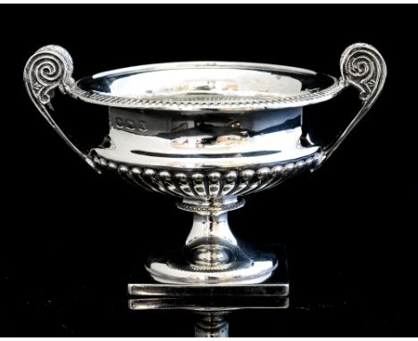 A George V silver two handle pedestal dish, in the Neo-Classical style, with lobed decoration to the lower half, atop a waist