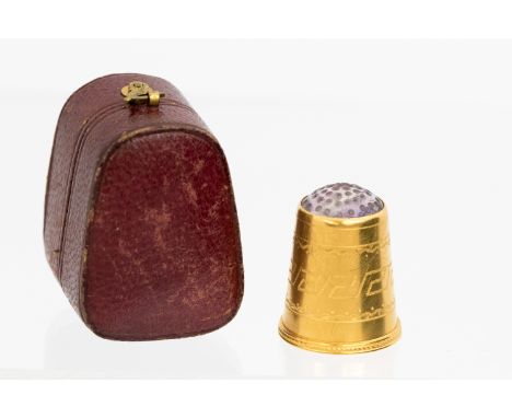 A cased Victorian 15ct gold and amethyst inset thimble with Greek key style chased ornament, stamped in maroon, morocco case