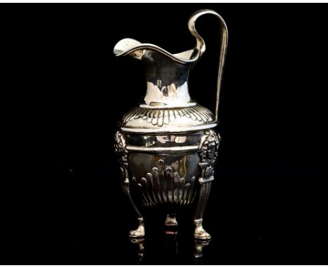 A George III silver Neo Classical style cream pitcher, of urn form with elongated loop handle, atop three paw feet with mask 