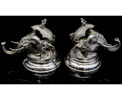 A pair of 20th Century white metal Raj Indian inkwells in the form of elephant heads, each with a terminal of a seated monkey