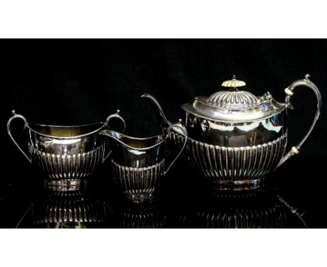 A Victorian silver three piece bachelor's tea service, modelled in the Queen Anne style with fluted decoration, sponsor's mar