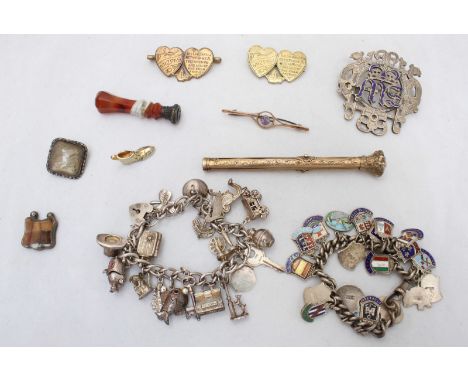 Two silver charm bracelets, one with numerous attached novelty charms, the other with hanging crests from various towns and p