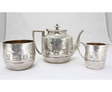 A Victorian three-piece silver tea set, decorated in an Anglo Indian style, with chased and embossed decoration and a band of