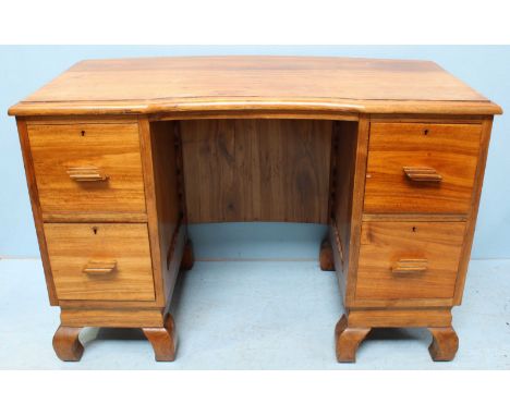 A 20th Century Mukwa wood pedestal desk, the top with concave centre, above two pedestals, each with two drawers and raised o