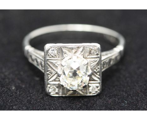 A 1930's solitaire diamond and palladium dress ring, centrally claw-set with a Victorian cushion-cut diamond set above a squa