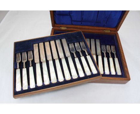 An early 20th Century twelve-piece silver dessert set, with mother-of-pearl handles and silver blades, in oak box with two tr