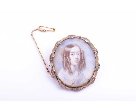 An early 19th century portrait miniature in a gold brooch mount, the oval ivory plaque depicting a young woman with ringlette