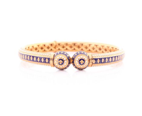 A yellow metal and enamel bangle; hinged with concealed push button clasp and lattice pierced interior, decorated throughout 