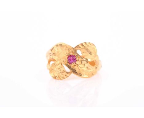 An Indian yellow metal and red stone ring, the bright-cut foliate mount inset with a single red paste stone, unmarked, size J