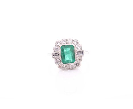 A platinum, diamond, and emerald ring, set with an emerald-cut emerald of approximately 1.60 carats, surrounded with a border