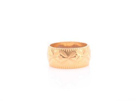 A yellow metal band ring, with repousse decoration, unmarked, size K.Condition report: 5.8 grams.