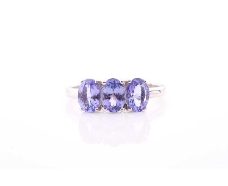 A 9ct yellow gold and tanzanite ring, set with three mixed oval-cut tanzanite, each stone measuring approximately 7 x 5 mm, s