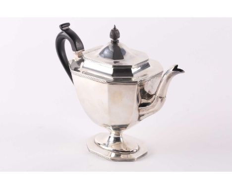 A silver teapot; London 1908 by Thomas Bradbury and Sons; octagonal with reeded borders and on a reeded skirt foot; with ebon