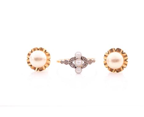 An Edwardian diamond and pearl ring; with three small pearls set vertically between rose diamond set foliate shoulders with m