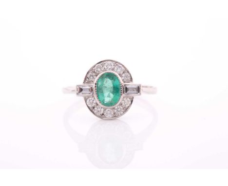 A platinum, diamond, and emerald dress ring, set with a mixed oval-cut emerald, within a border of round-cut diamonds, with a