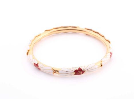 A red and white enamel bangle, the enamelled flowerheads curved over a rigid gilded band.