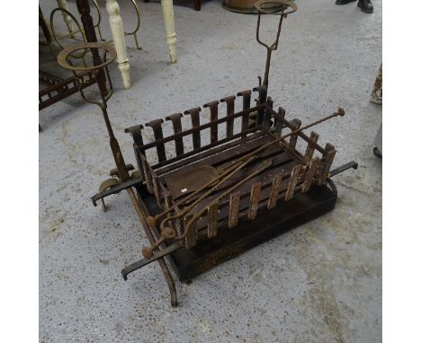 A cast-iron fire grate, a pair of fire dogs, and a companion set 
