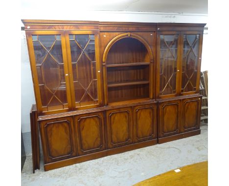 A reproduction mahogany 3-section display cabinet, intersection having an arch-top and 2 adjustable shelves, with lattice-gla