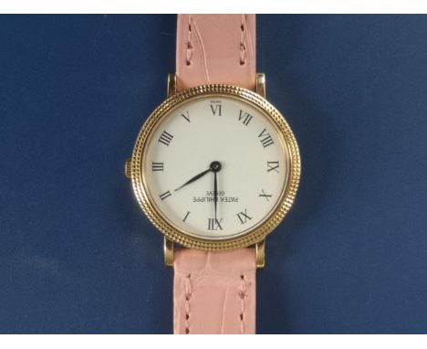 A boxed lady's 18ct gold Patek Philippe Calatrava quartz wrist watch, having white dial, black roman numerals, on pink crocod