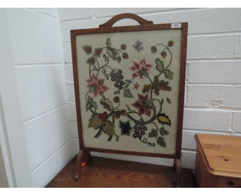 A mid 20th century golden oak frame embroidered firescreen