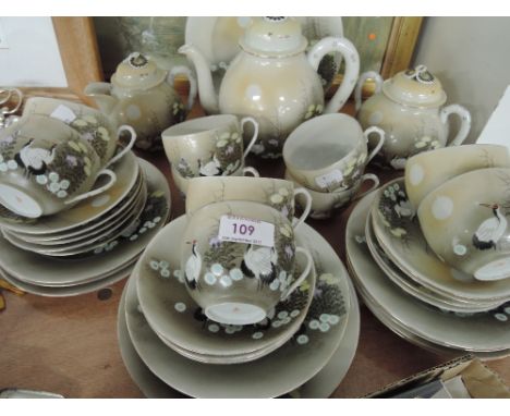 A part tea service in egg shell china with hand painted oriental scene 30 pieces approx