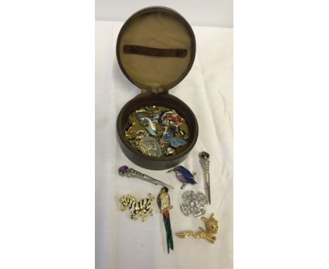 A collection of costume brooches including enamelled examples. Including Celtic design and animals.  In a vintage leather col