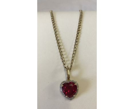 9ct gold pendant set with a large heart shaped created ruby. Set in a heart shaped mount with small diamonds in an illusion s