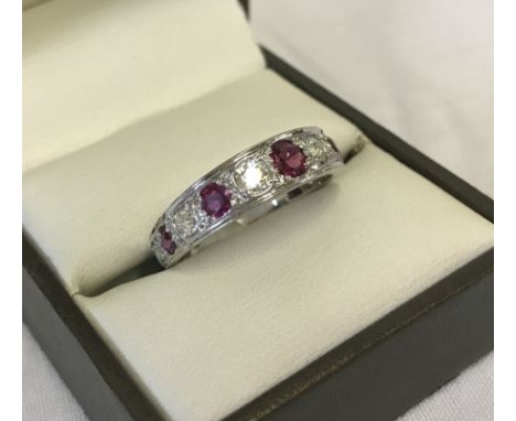 White gold, diamond & ruby ¾ eternity ring. 7 diamonds ranging in size from approx. 0.20ct - 0.07ct, total carat weight appro