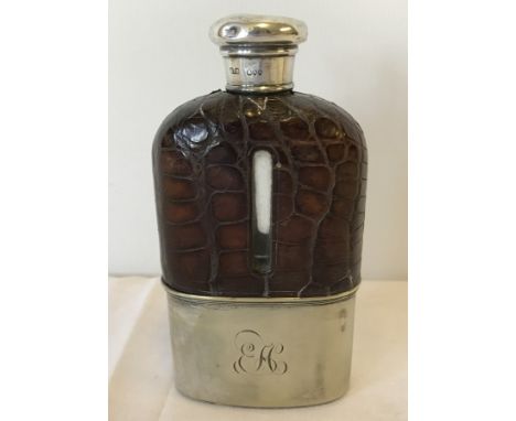 A silver topped hip flask with leather casing to top and silver plate bottom. Monogrammed E.M. London 1887. 