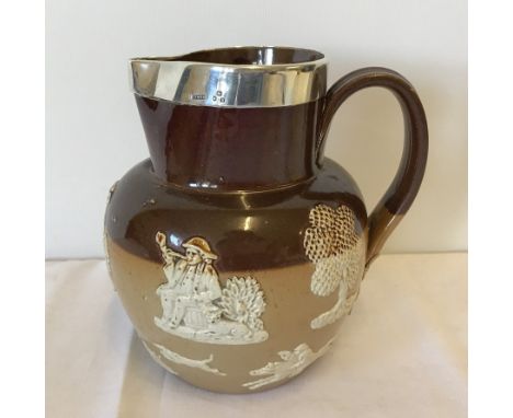 A thick silver rimmed Doulton Lambeth ceramic jug. With raised hunting and drinking scenes. London 1897. 