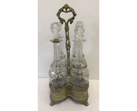 A silver plated 4 decanter galleried stand with decanters. 4 bottles have engraved vine decoration. Vine decoration to stand.